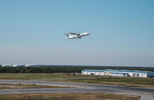 The image depicts an aircraft taking off from Yellowknife airport